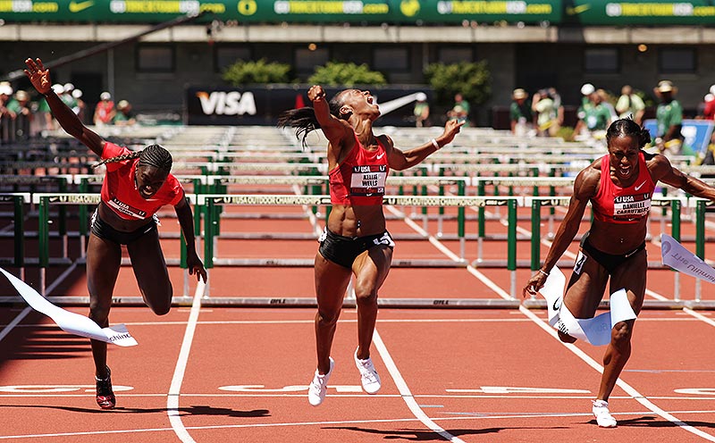Female track athletes reaching the finish line