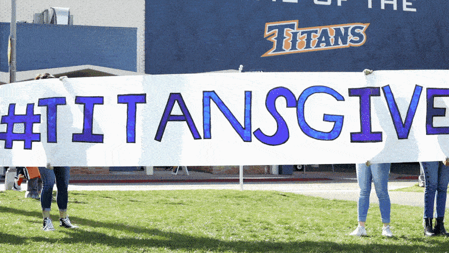 Tuffy running though "#TitansGive" banner