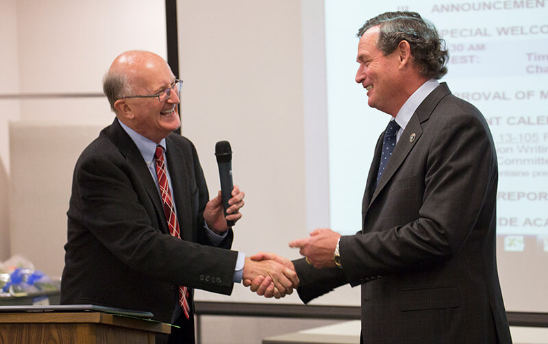 Bedell shaking hands with Chancellor White