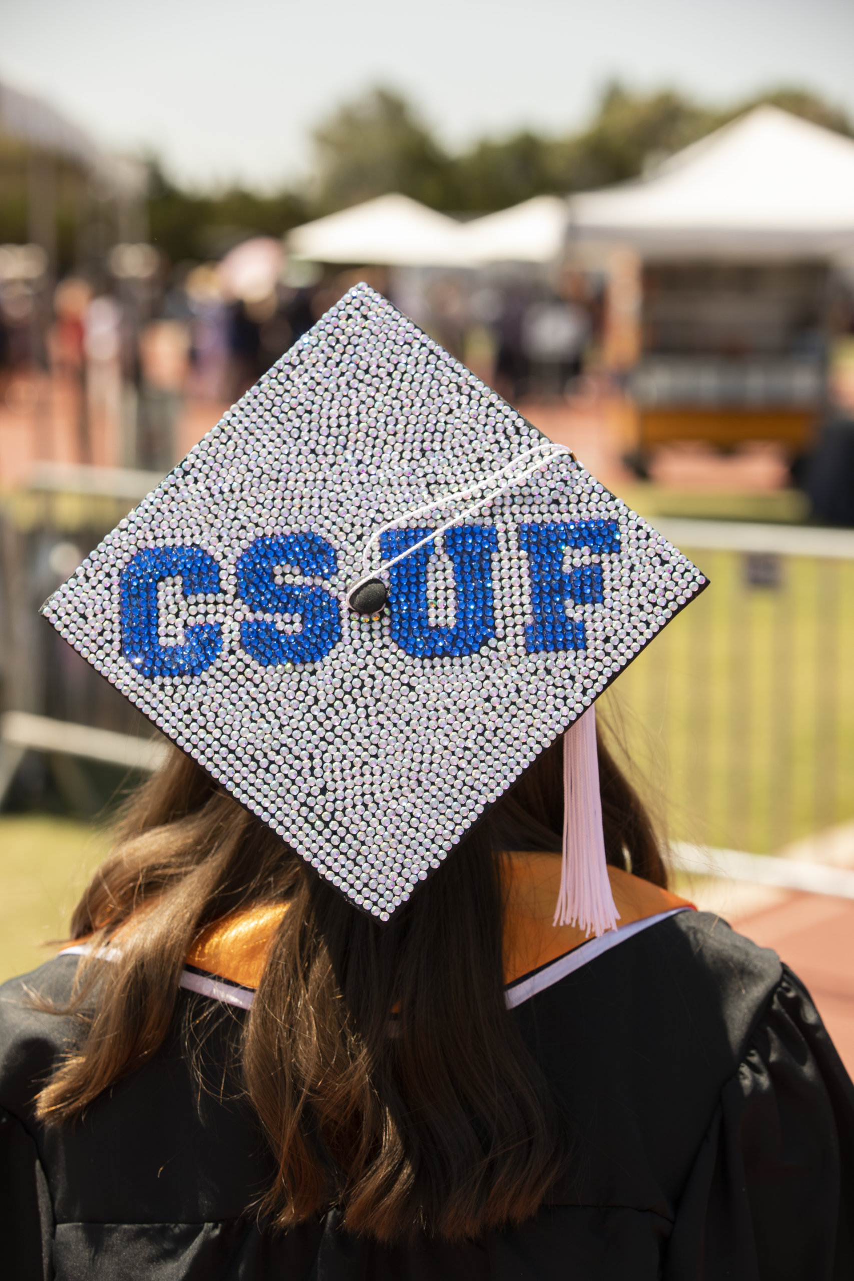 Bedazzled grad cap reads "CSUF" in