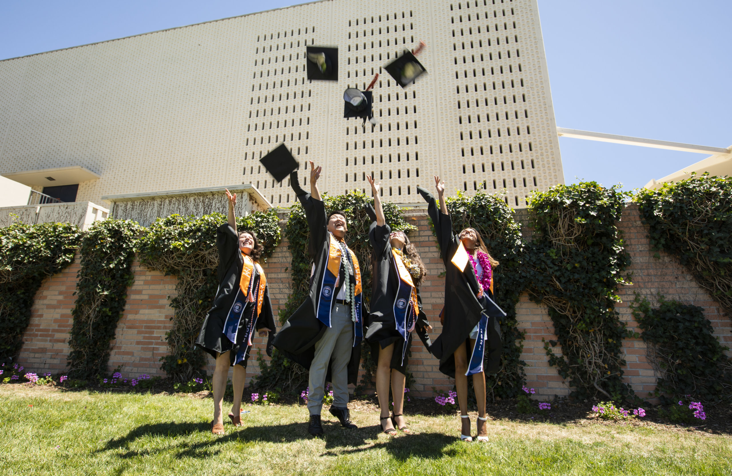 Four graduates throw their caps