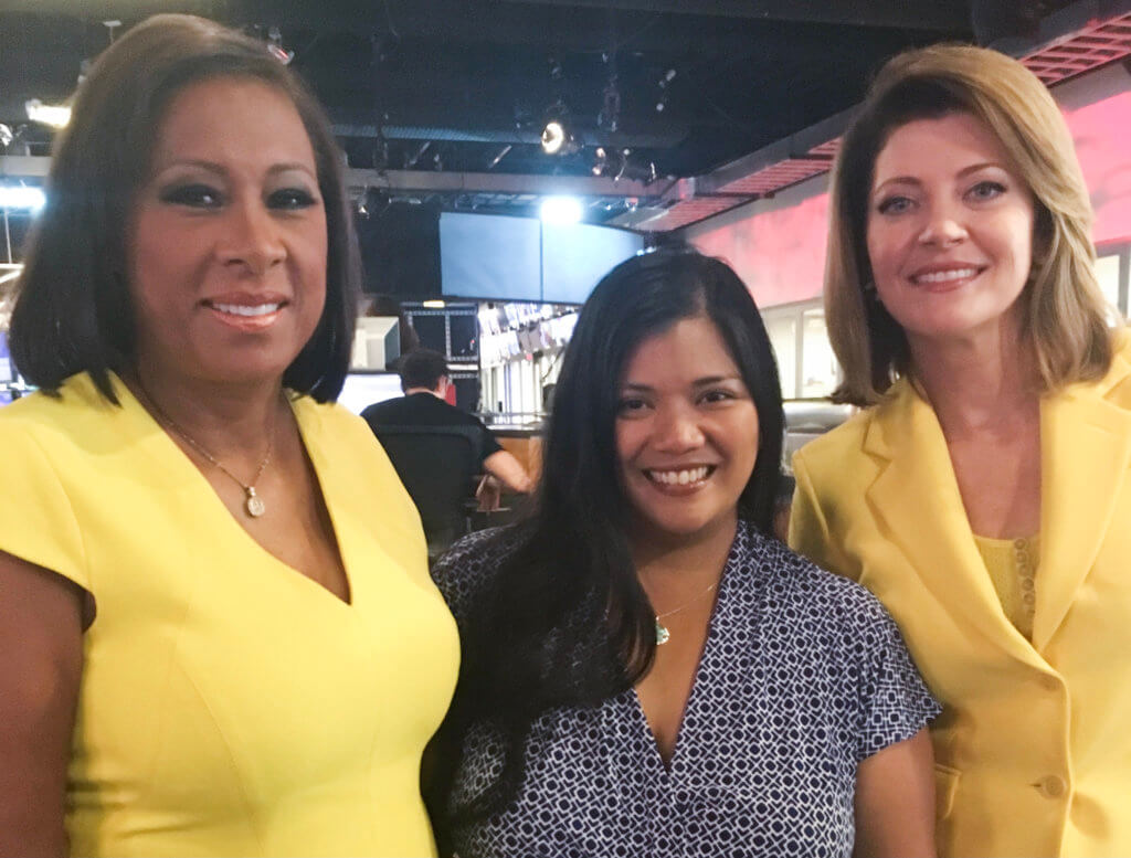 Alumna Darleene Barrientos flanked by broadcast personalities