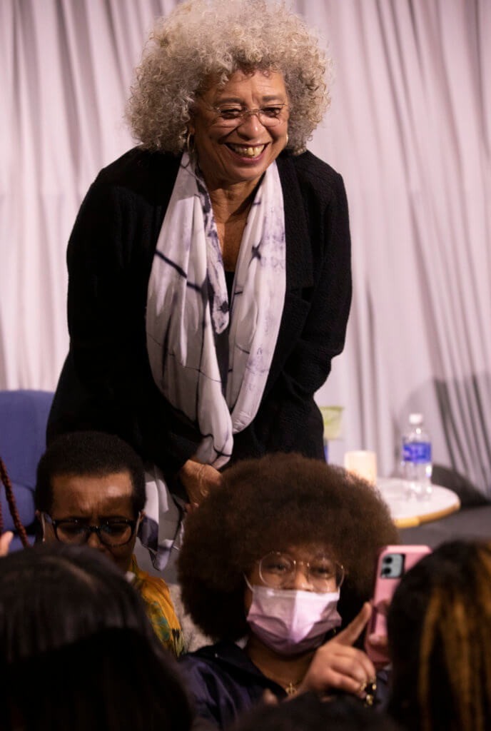 Angela Davis takes a photo with a student.