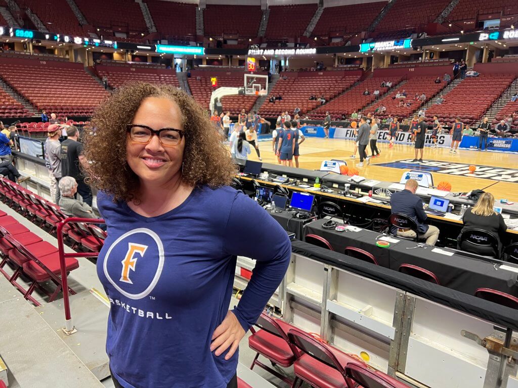 woman in a gym wearing glasses, smiling 