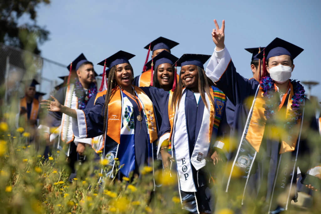 Group of graduates in regalia smiling at camera