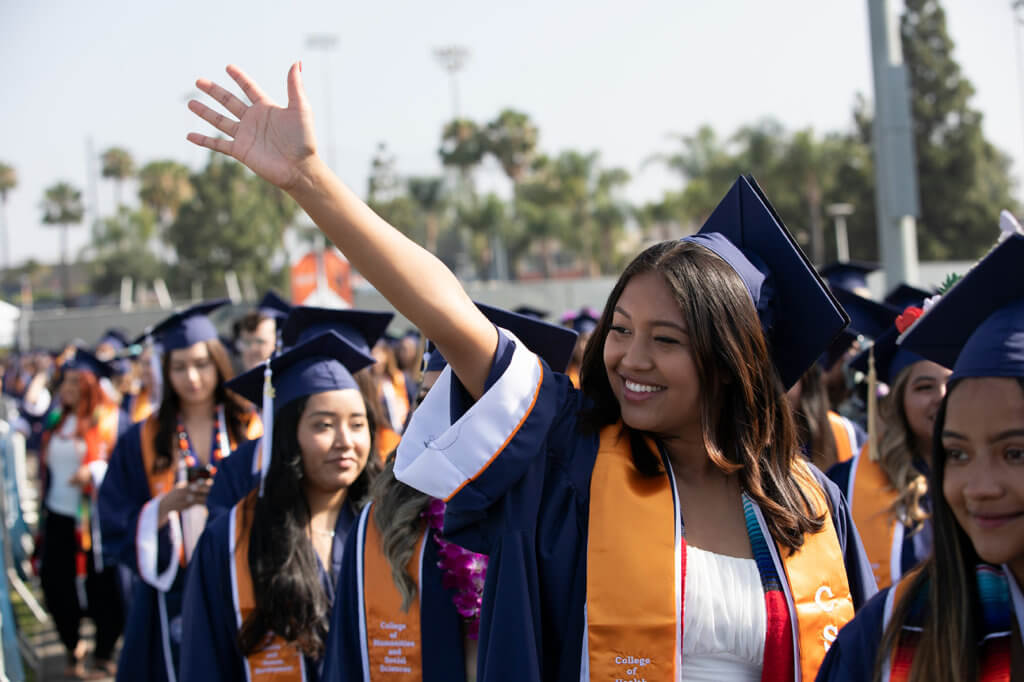 Graduate waves to crowd