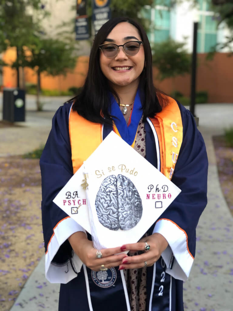 Vanessa Barragan poses with decorated grad cap that reads "Si se Pudo"