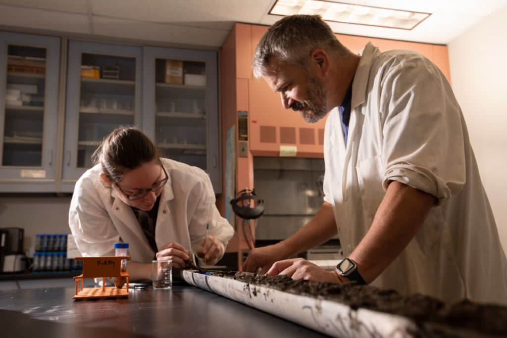Ashley Hansen and Matthew E. Kirby inspect sediment core sample