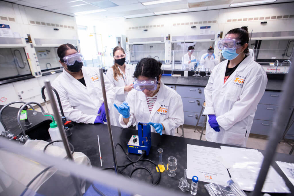 Adriana Rodriguez, center, conducts an experiment during the STEM Academy.