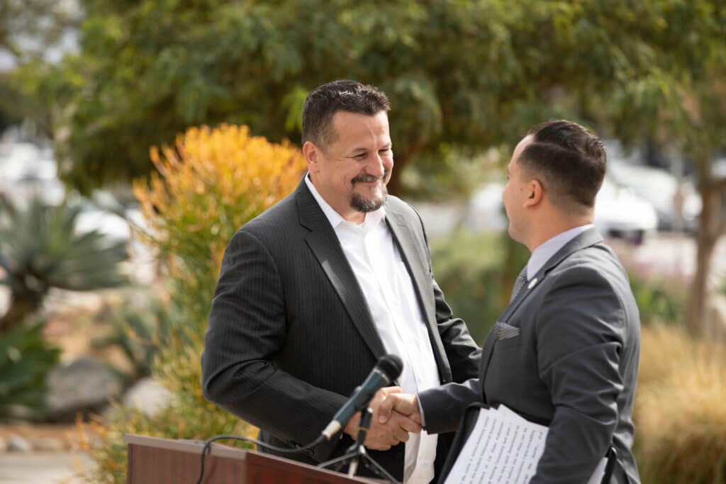 Cameron Cook shakes James Anthony Burandt's hand