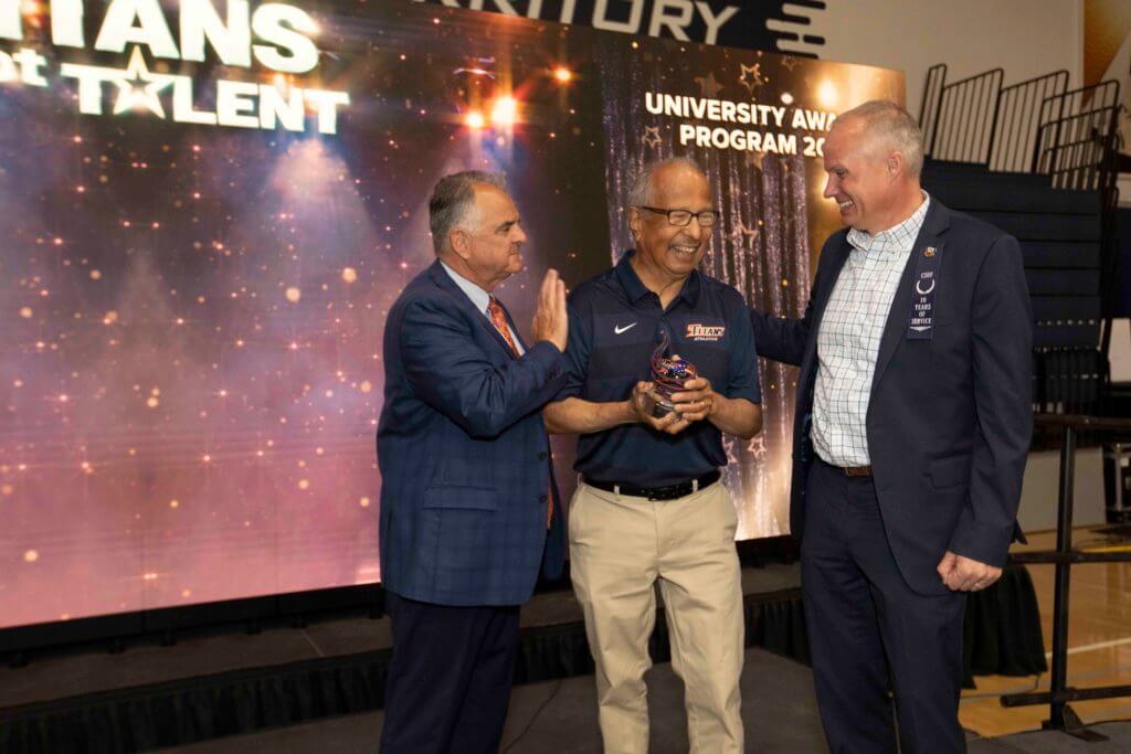 Joe Camacho receives award from David Forgues and President Virjee