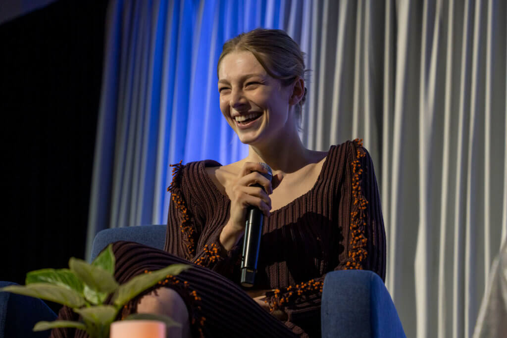 Hunter Schafer smiles while holding microphone