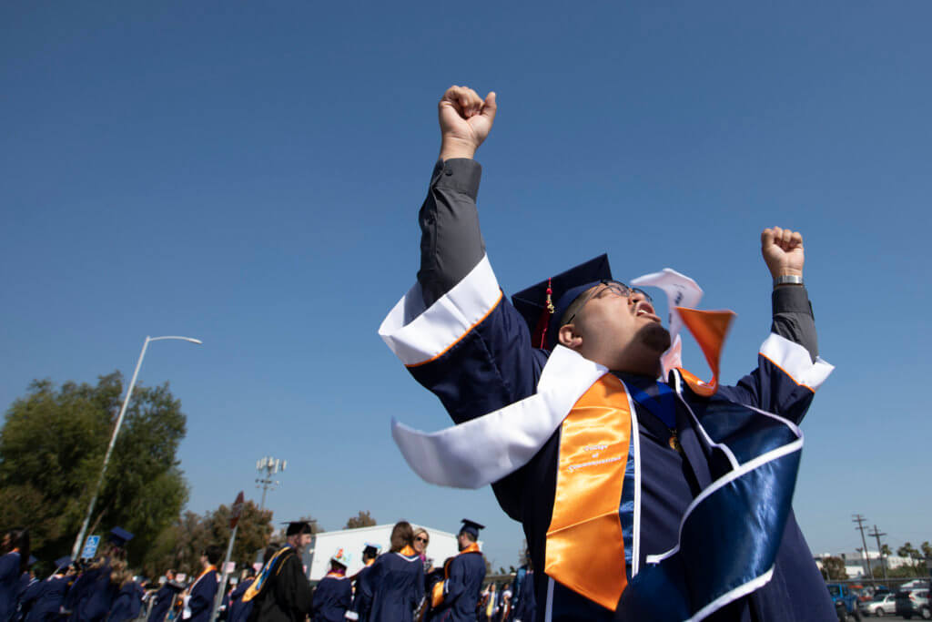 Graduate raises hands in air