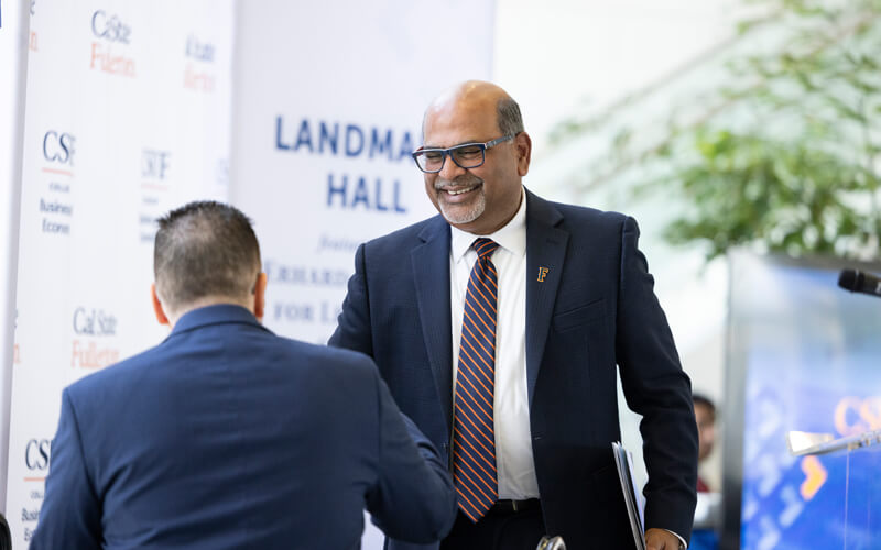 Sri Sundaram, dean of the College of Business and Economics smiling and shaking hands with an attendee at the June 5 groundbreaking for Landmark Hall