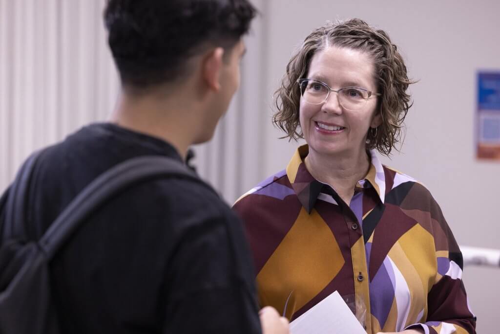 Urban learning director Calli Lewis Chiu talks to a student in program