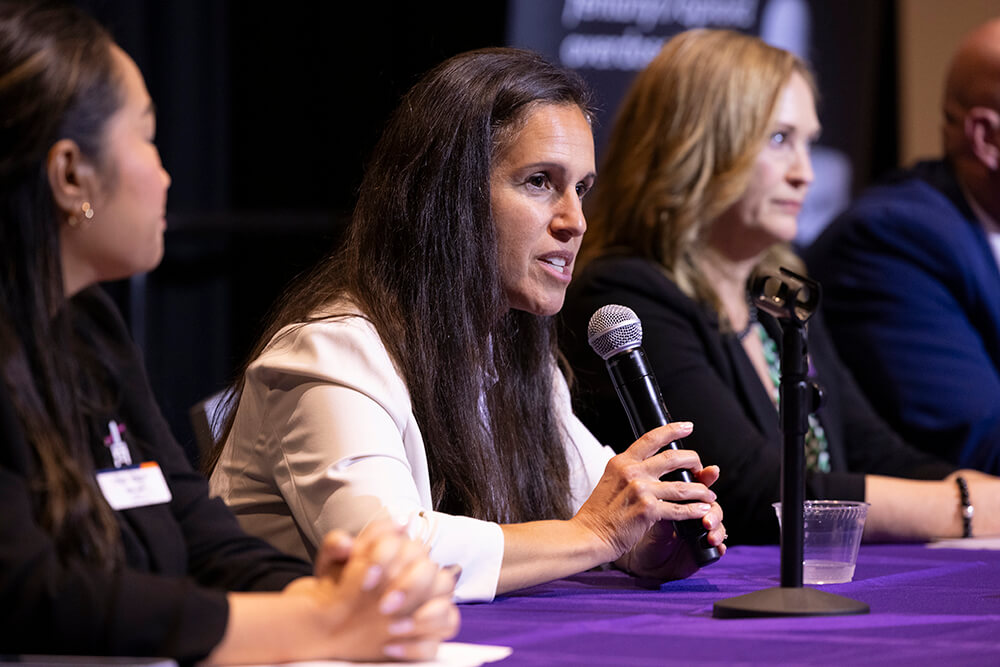 Dean of the College of Health and Human Development Celestina Barbosa-Leiker speaking into a microphone at CSUF's Feb. 5 opioid crisis town hall event in the Titan Student Union