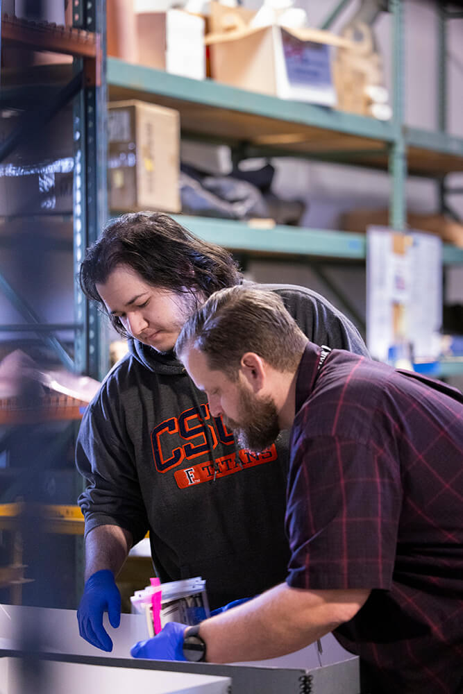 Eli Wolcott, left, works with Lead Archivist Brent Ogden