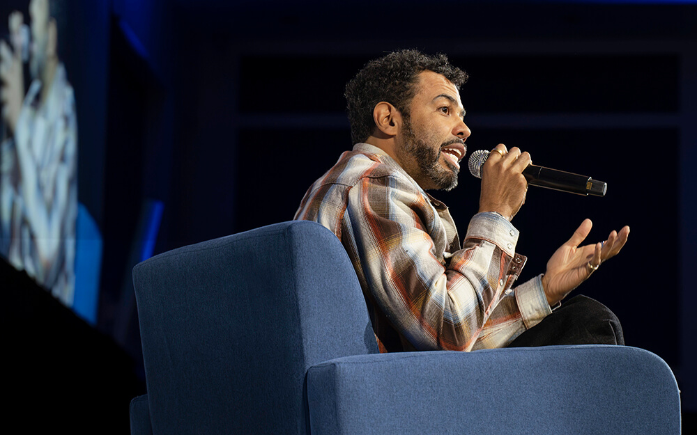 "Hamilton" star Daveed Diggs sits in a chair and speaks into a microphone at CSUF's Feb. 20 Beyond the Conversation event.