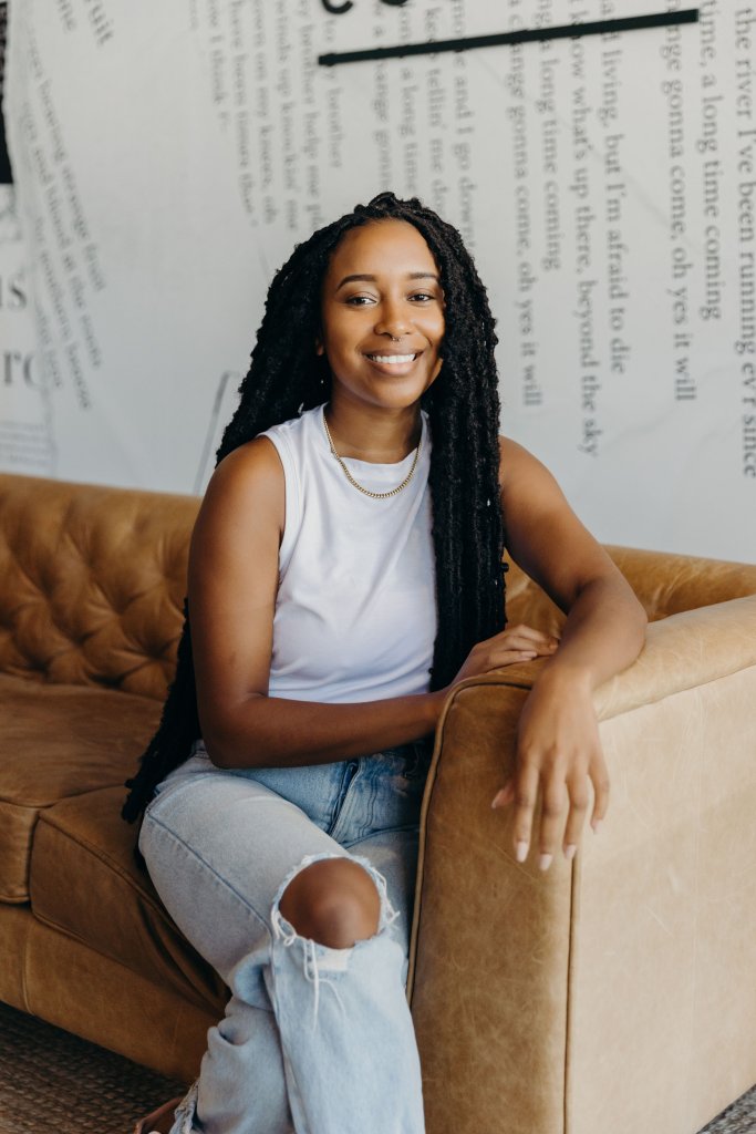 Onikah Asamoa-Caesar sits in a chair in Fulton Street Books & Coffee