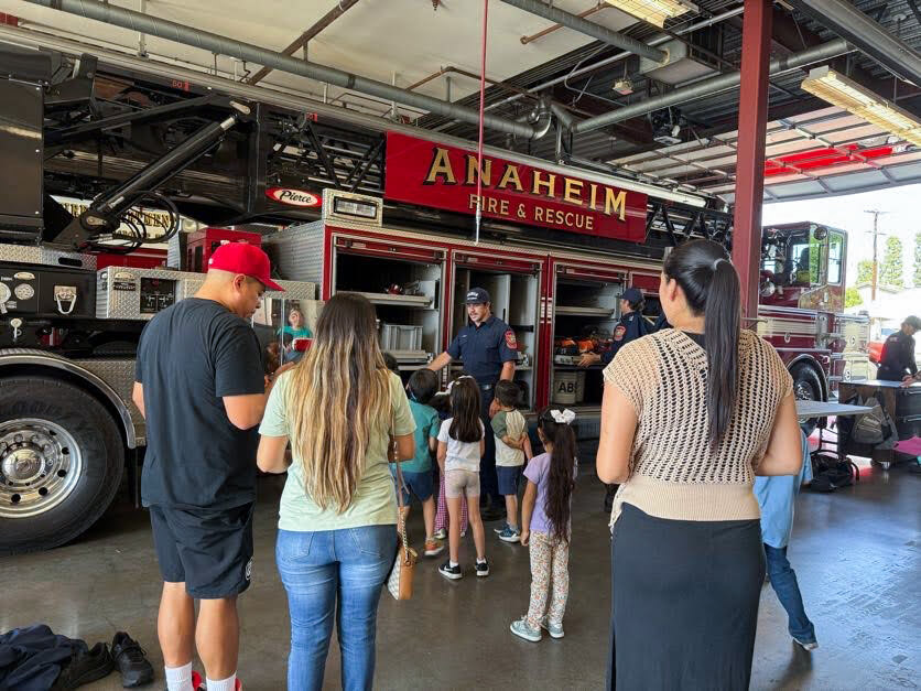 Kindergarten students and their families visit a fire station.