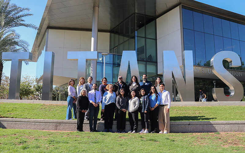 A group of Cal State Fullerton employees who work on sustainability projects and programs pose in front of the Titan Student Union.