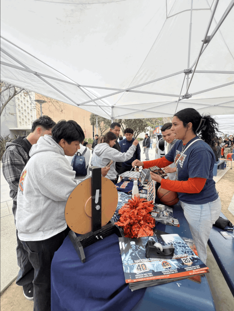 Kimberly Noriega works at a table on the CSUF campus promoting Titans Athletics