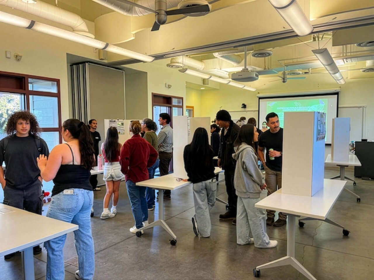 Groups of people around varying poster boards discussing.