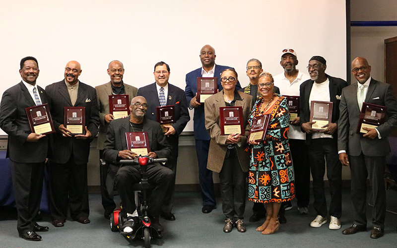 A crowd of CSUF alumni holding plaques