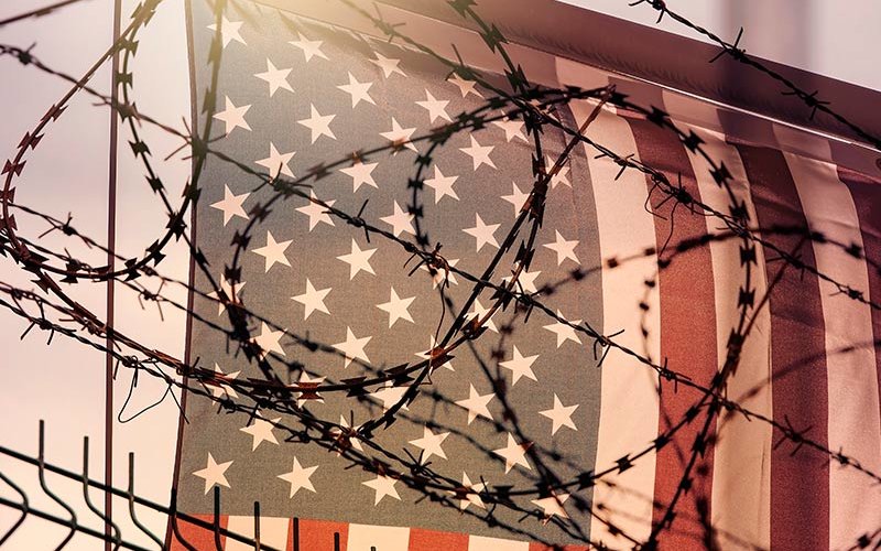 American Flag behind barbbed wire