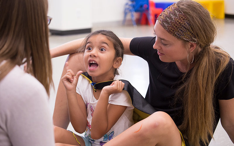 Francesca Stuart, center, has a breakthrough with Titan Tykes mentors Amy Reeves, left, and Megan Callender, right.