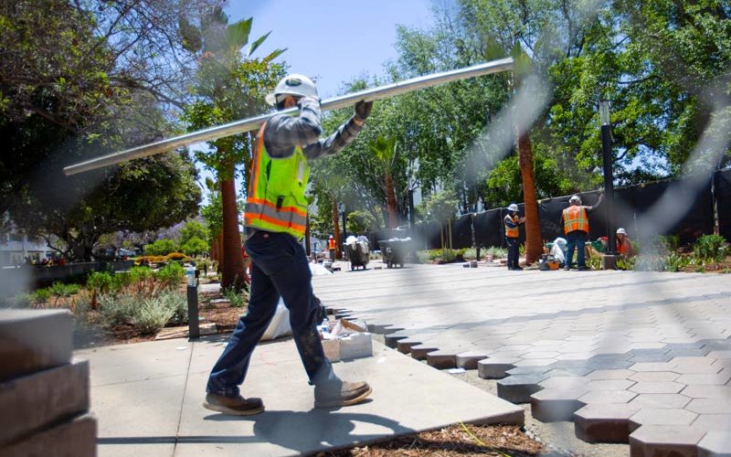 Worker with construction material walks over new promenade.