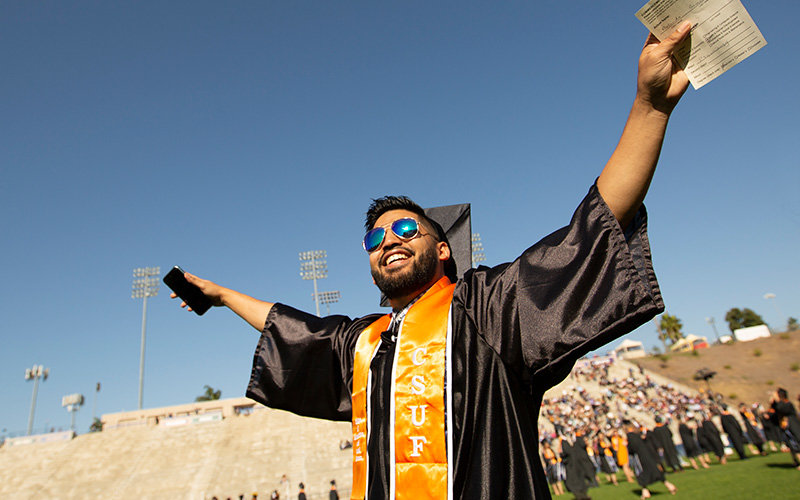 A student celebrating during Commencement procession.
