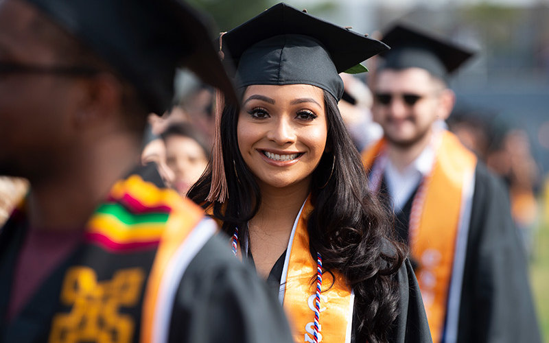 Graduate smiling in commencement line.