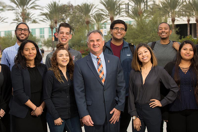 Photo of President Virjee with CSUF students.
