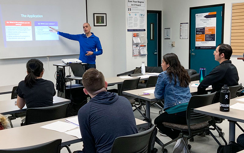 Atul Teckchandani teaching in classroom.