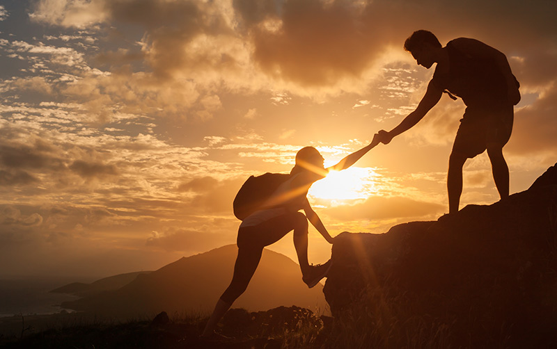 Hikers help each other up.