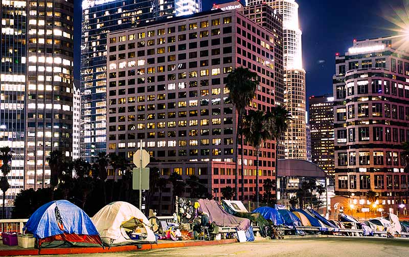 A homeless encampment in front of the Los Angeles Skyline.