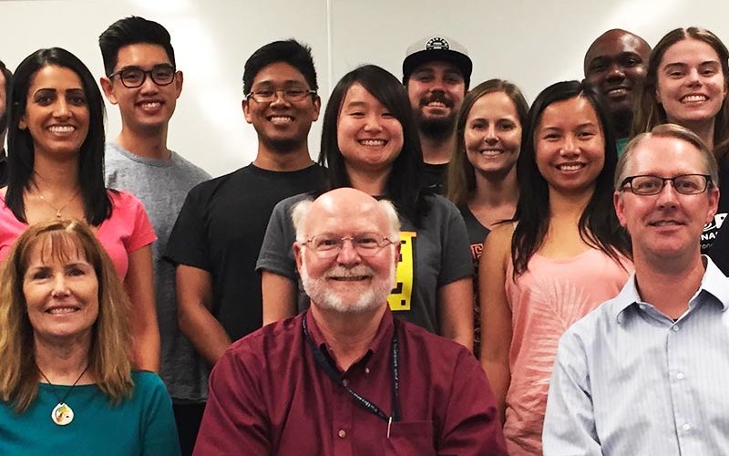 Math Fellows, two men and a woman with group of students, all smiling