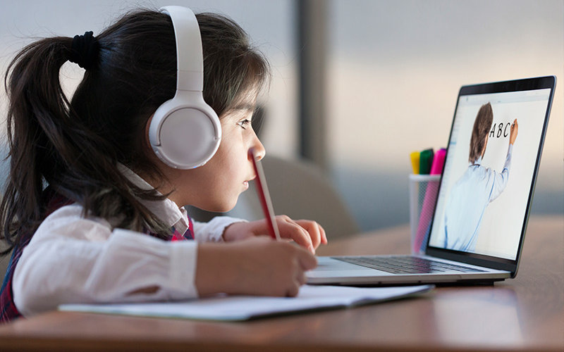 Child learns online with laptop.