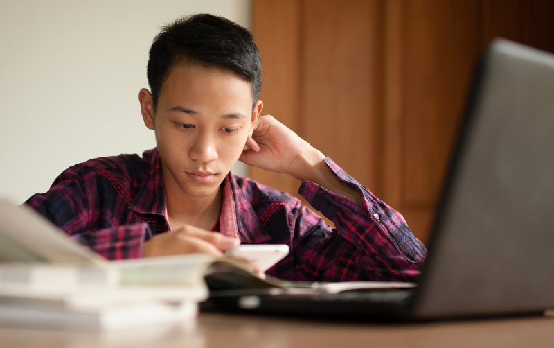 Disconnected youth learning at computer online.