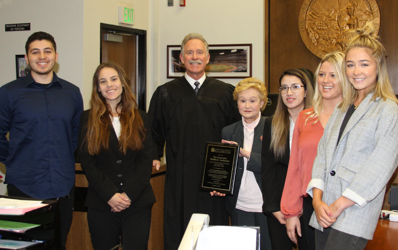Students visit with Judge in courtroom.