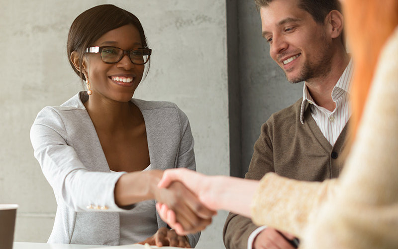 Business woman shakes hands with colleague.