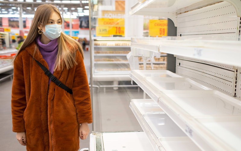 Shopper looking at empty store shelving.
