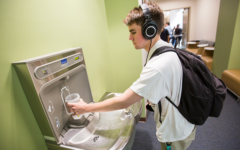 Refilling a water bottle.
