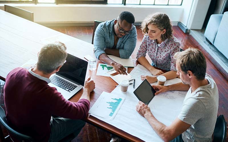 Group of professionals working together at conference table.