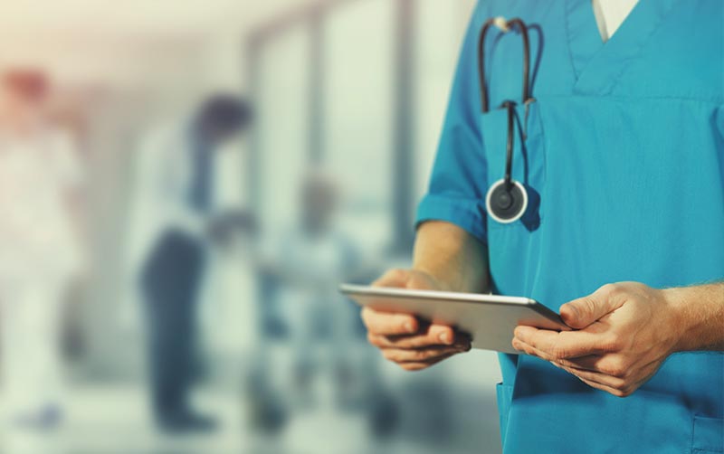 Doctor holds tablet.
