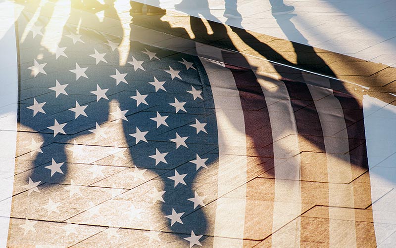 Human shadows behind American flag