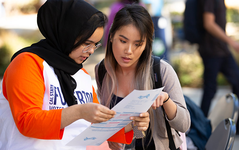 Maisune Abu-Elhaija helps register Leann Dinh.