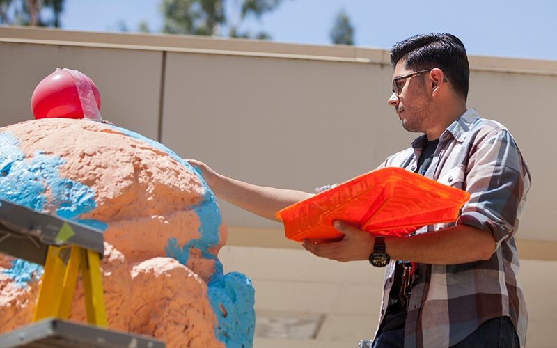 Animation student Omar Gomez paints the ice cream sculpture.