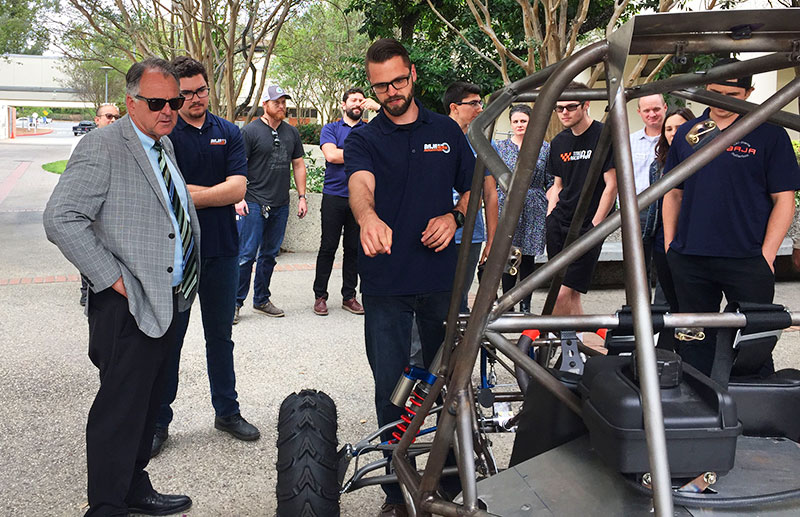 ECS students showing the Baja race car to CSUF President Virjee.